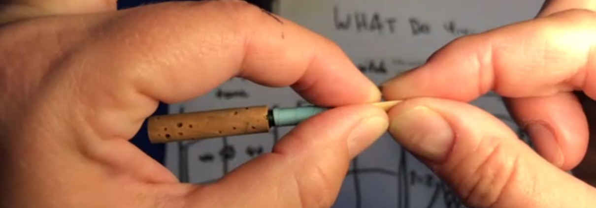 Hands adjusting opening and tension of an oboe reed